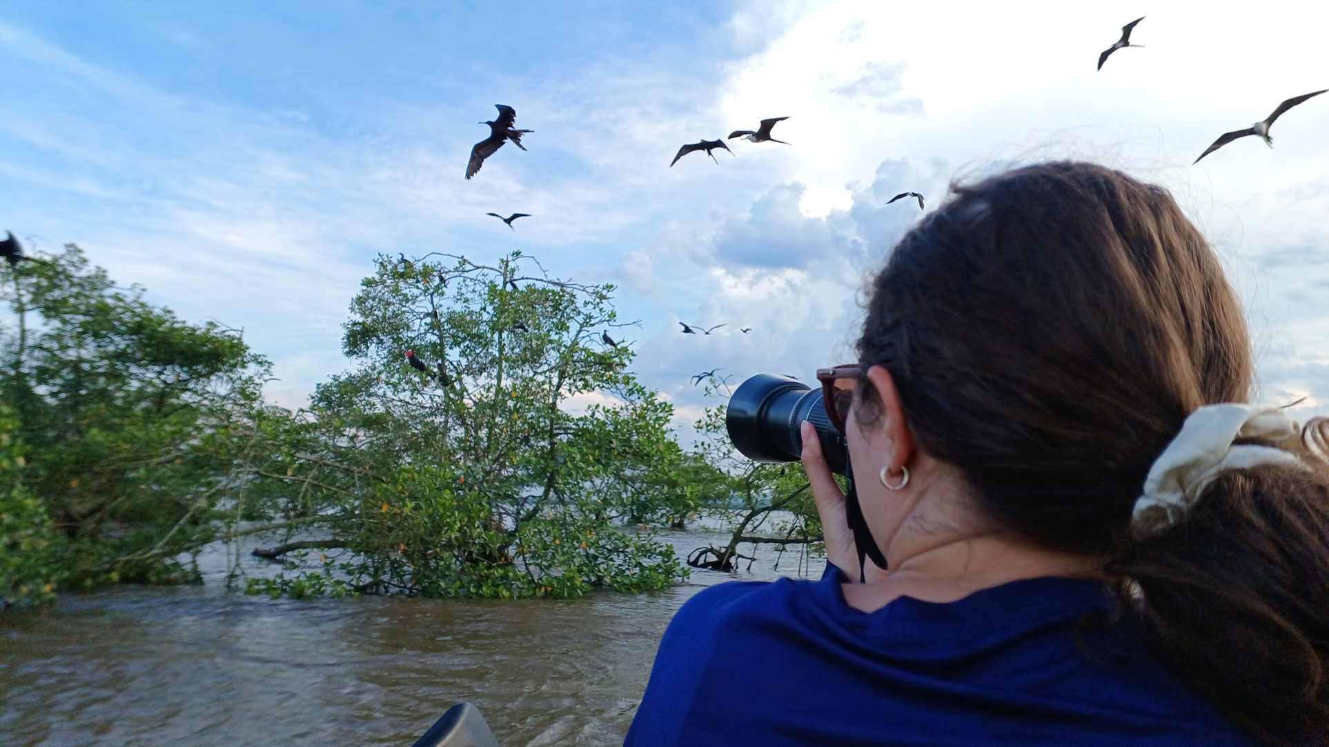 Pesquisadora realizando registro de fragatas (Fregata magnificiens) em censo embarcado