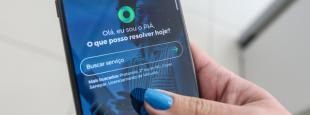 Mão feminina segurando um celular com aplicativo PIÁ